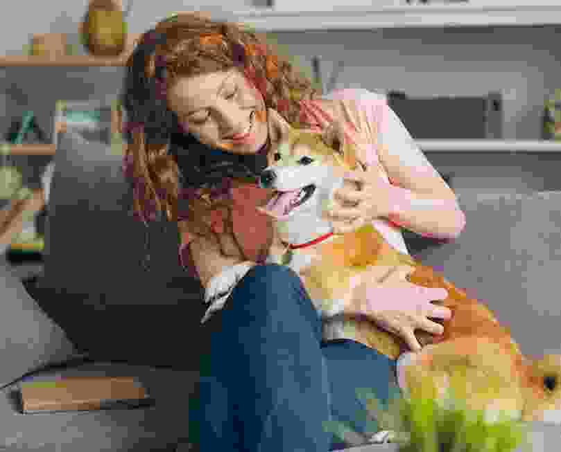 woman petting her dog with a waggy tail